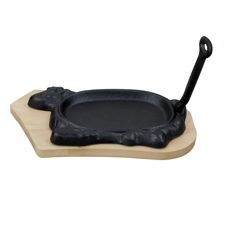 Cast iron cow-shaped sizzling pan on a wooden tray