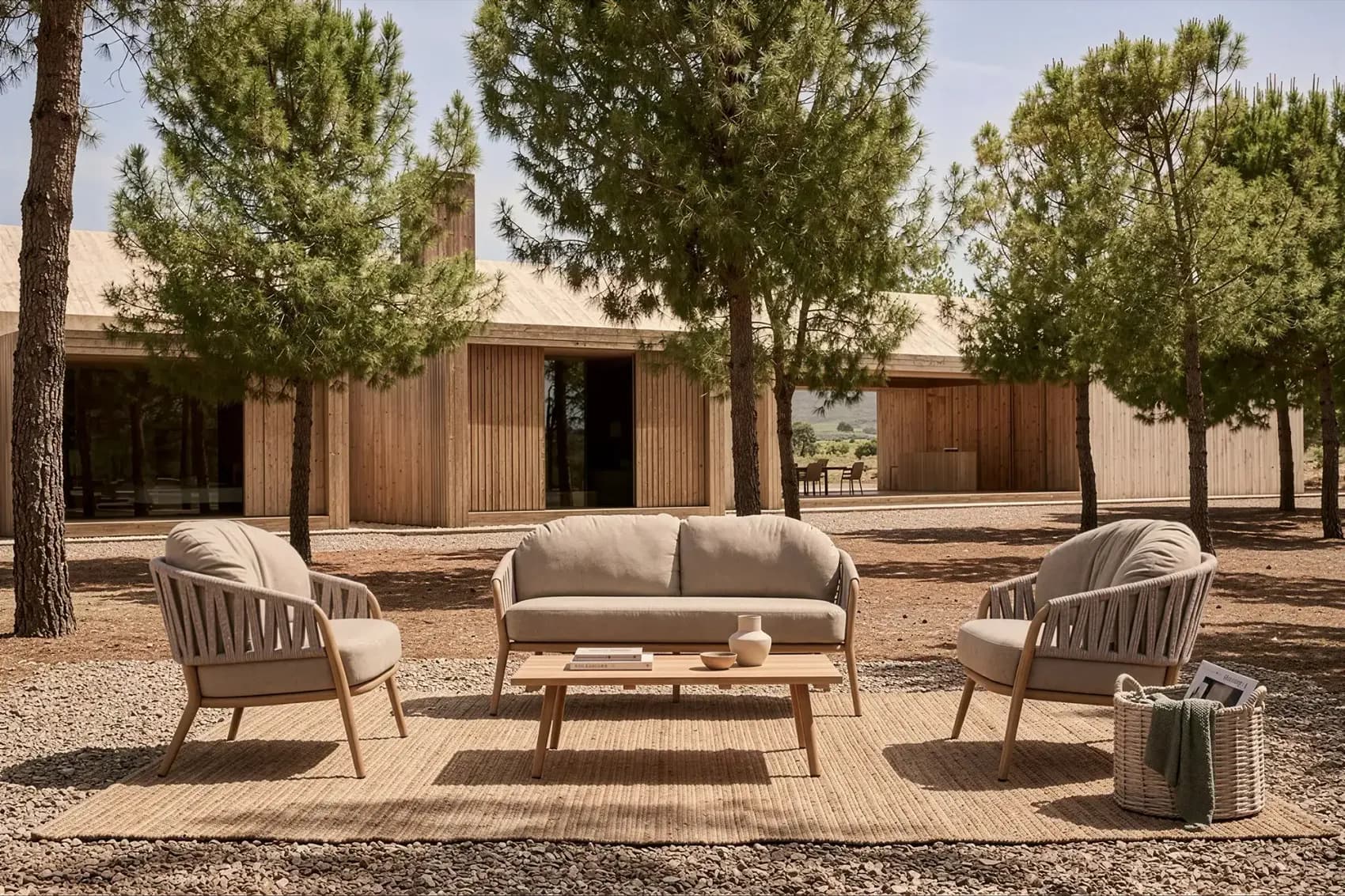 Rope woven outdoor sofa set with a low table on a gravel terrace
