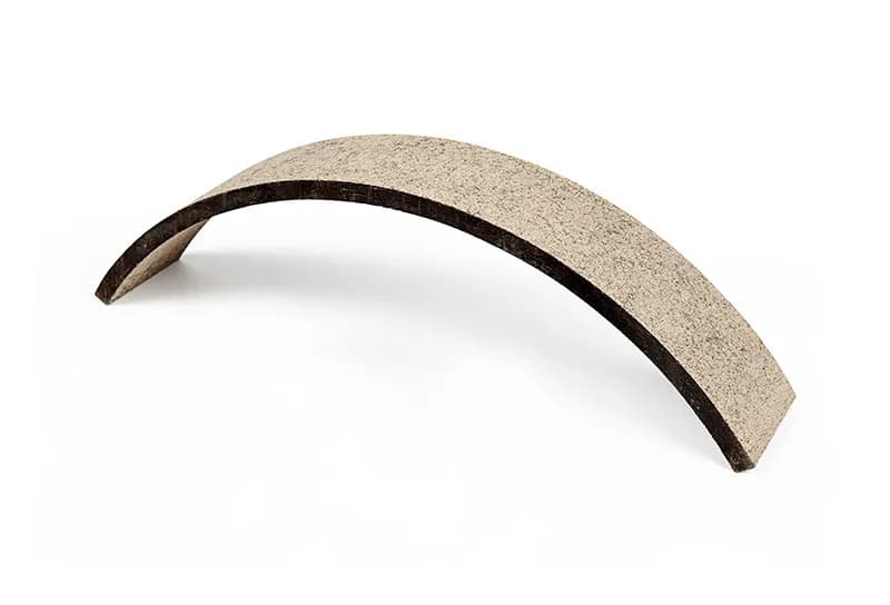 Smooth curved brake lining strip on a white background