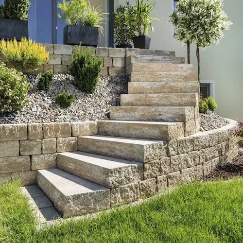 Stone block steps leading up a landscaped slope