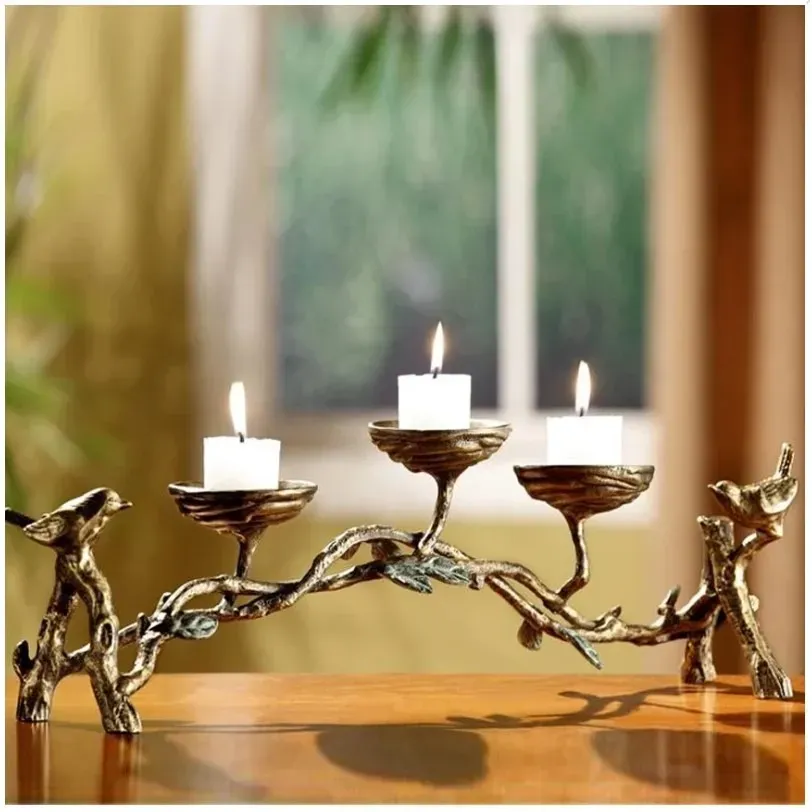 Metal candle holder shaped like a branch with three candle cups and birds