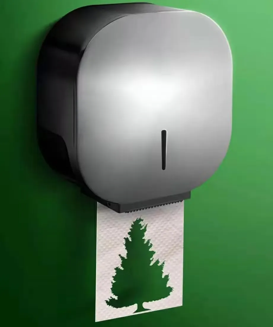 Silver and black jumbo roll dispenser on a green wall